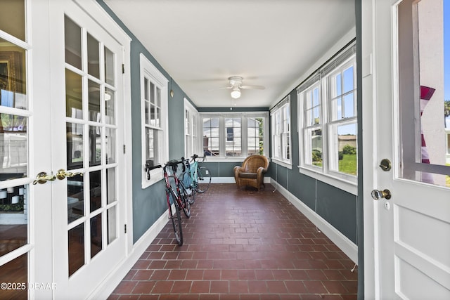 sunroom / solarium featuring ceiling fan