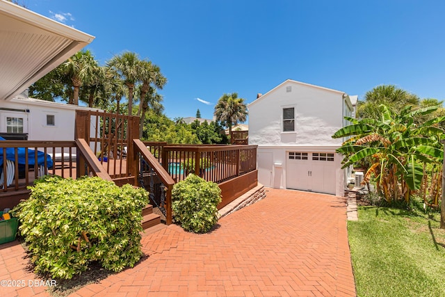 exterior space with a garage and a wooden deck