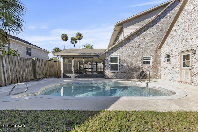 view of swimming pool with a sunroom, a fenced backyard, a patio area, and a fenced in pool