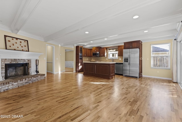 kitchen featuring open floor plan, light countertops, appliances with stainless steel finishes, decorative backsplash, and beamed ceiling