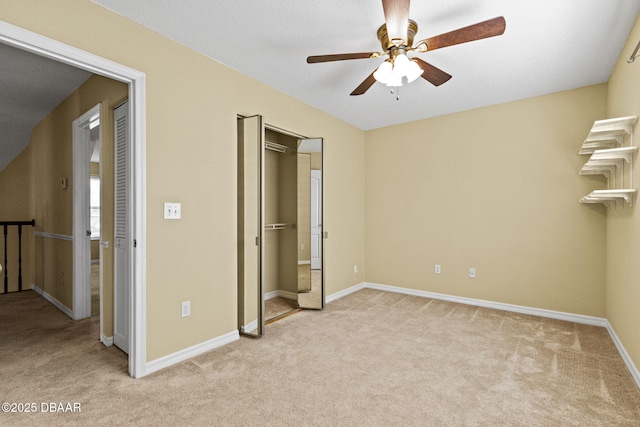 unfurnished bedroom featuring light carpet, a closet, a ceiling fan, and baseboards