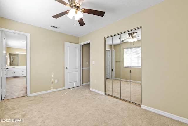 unfurnished bedroom featuring baseboards, a closet, visible vents, and light colored carpet