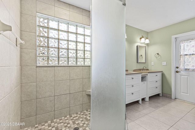 bathroom featuring tile patterned flooring, walk in shower, and vanity