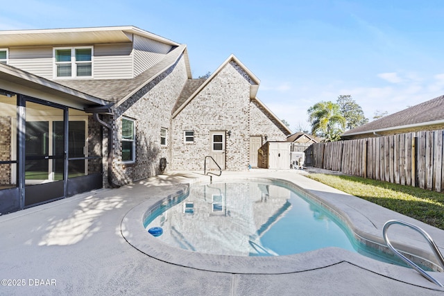 view of pool featuring a fenced in pool, a patio, a fenced backyard, a storage unit, and an outdoor structure