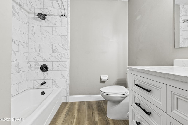 full bath featuring baseboards, toilet, vanity, wood finished floors, and shower / bathtub combination