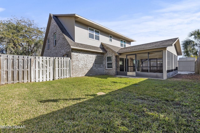 back of property featuring a fenced backyard, brick siding, a sunroom, a yard, and roof with shingles