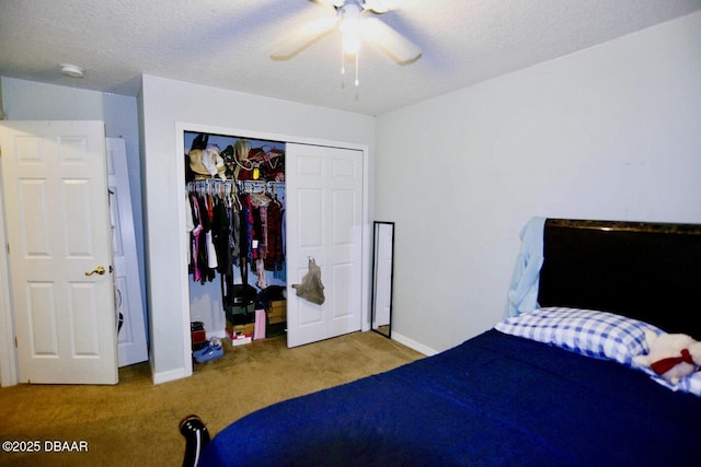 carpeted bedroom with a ceiling fan, a closet, a textured ceiling, and baseboards