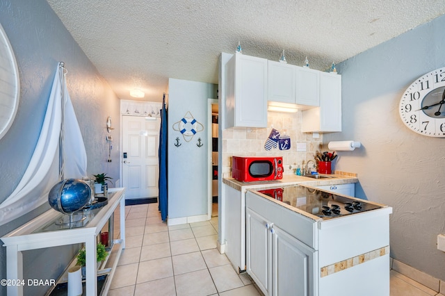 kitchen with light tile patterned floors, a textured ceiling, tasteful backsplash, and white cabinetry