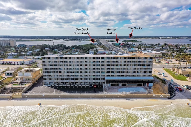 drone / aerial view with a water view and a beach view