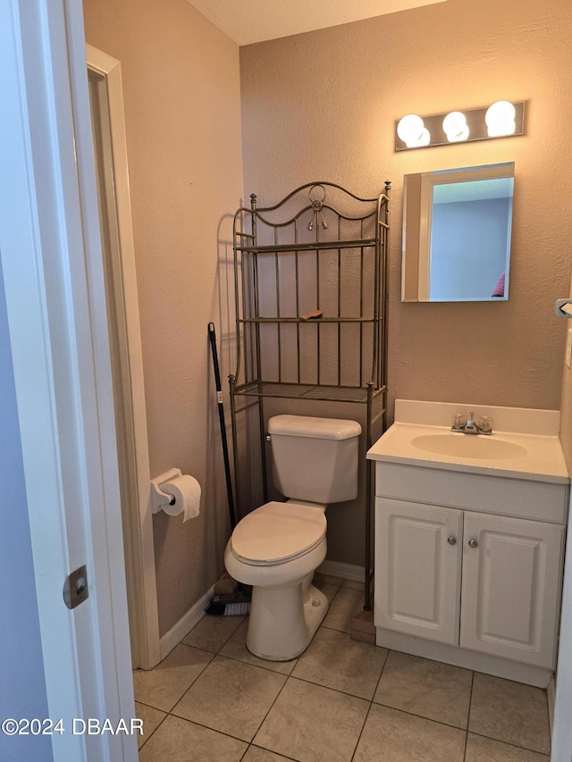 bathroom with tile patterned flooring, vanity, and toilet