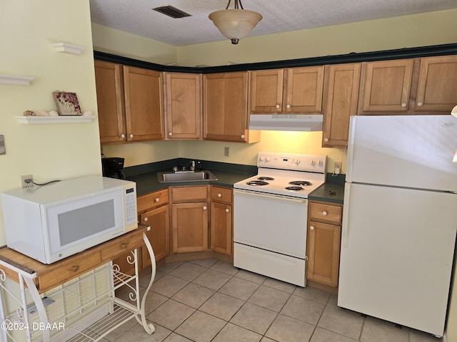 kitchen with white appliances, sink, a textured ceiling, and light tile patterned floors