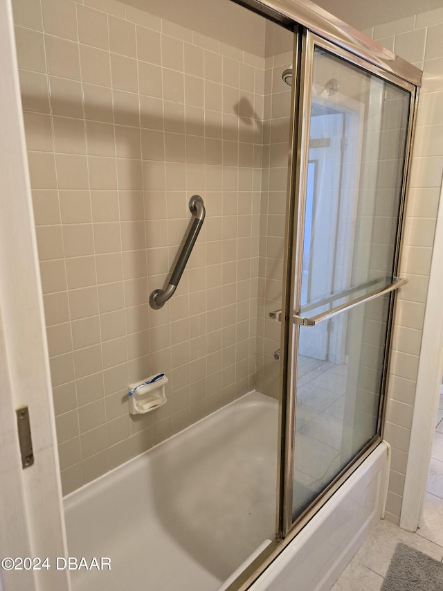 bathroom featuring tile patterned floors and shower / bath combination with glass door