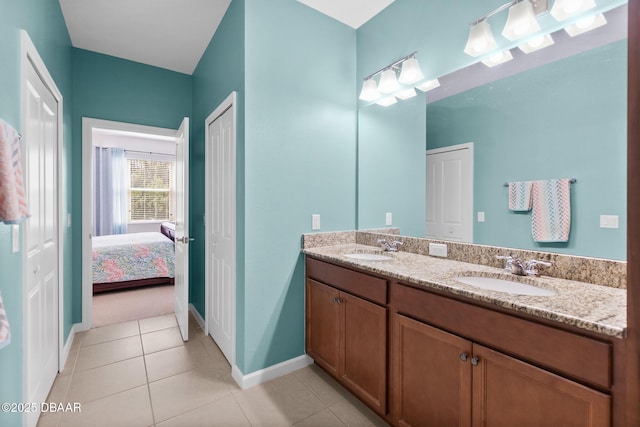 full bathroom with tile patterned floors, double vanity, baseboards, and a sink