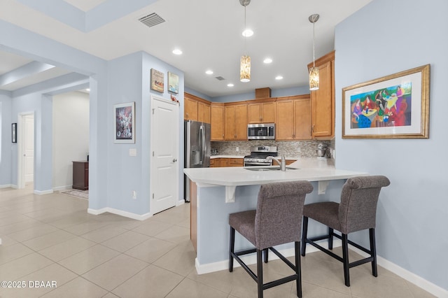 kitchen with visible vents, backsplash, stainless steel appliances, a peninsula, and light countertops