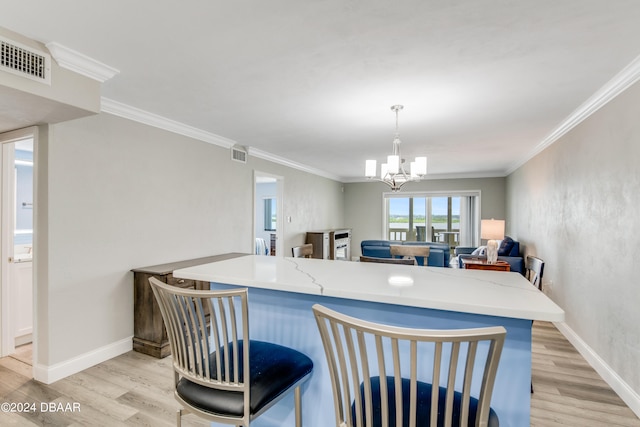 kitchen featuring ornamental molding, pendant lighting, and light hardwood / wood-style floors