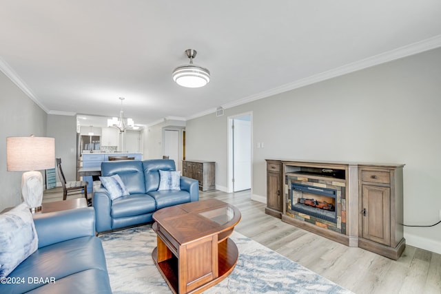 living room with light hardwood / wood-style floors, an inviting chandelier, and ornamental molding