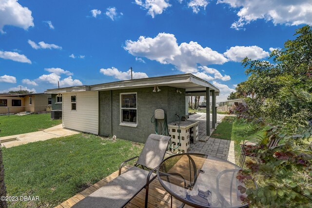 rear view of house featuring a lawn, central AC, and a patio