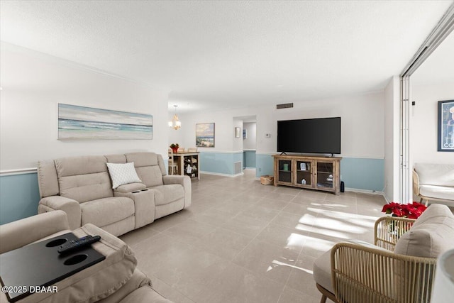 tiled living room with a textured ceiling and a notable chandelier