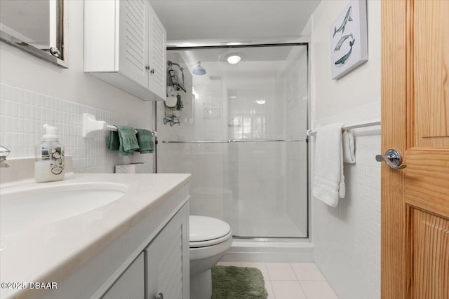 bathroom with tile patterned floors, an enclosed shower, vanity, tile walls, and toilet