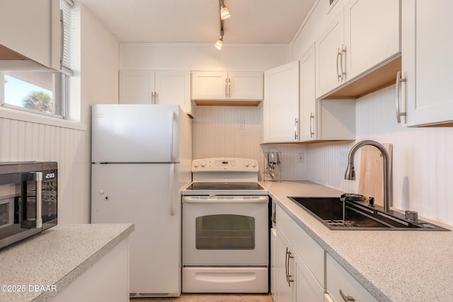 2727 N Atlantic Ave Unit 107, Daytona Beach, FL 32118 - kitchen with white appliances, white cabinetry, light countertops, and rail lighting