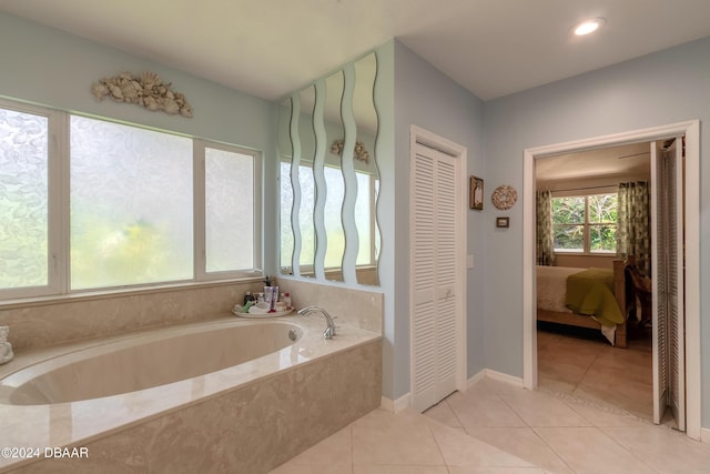 bathroom with tile patterned floors and tiled tub