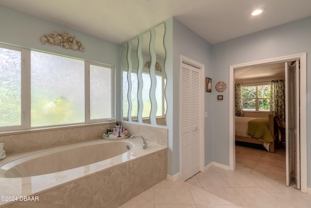 bathroom with tile patterned flooring and tiled bath