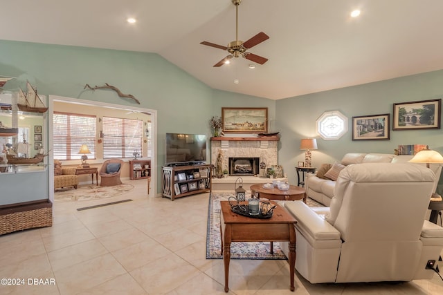 tiled living room featuring a fireplace, high vaulted ceiling, and ceiling fan