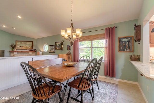 tiled dining space with lofted ceiling and an inviting chandelier