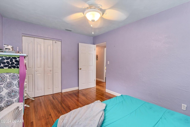 bedroom featuring hardwood / wood-style flooring, ceiling fan, and a closet