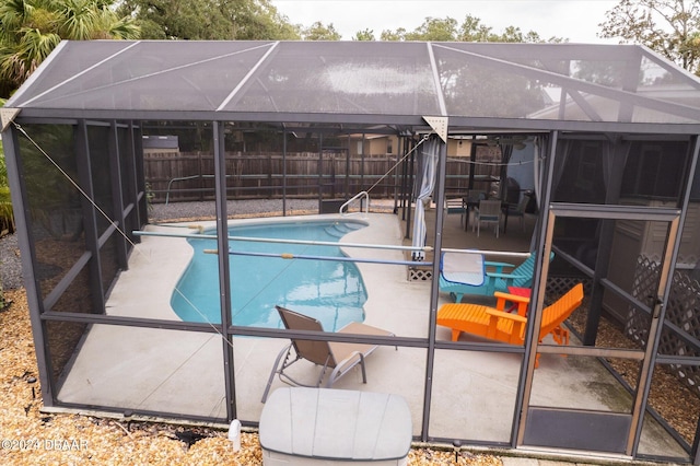 view of swimming pool featuring a patio area and a lanai