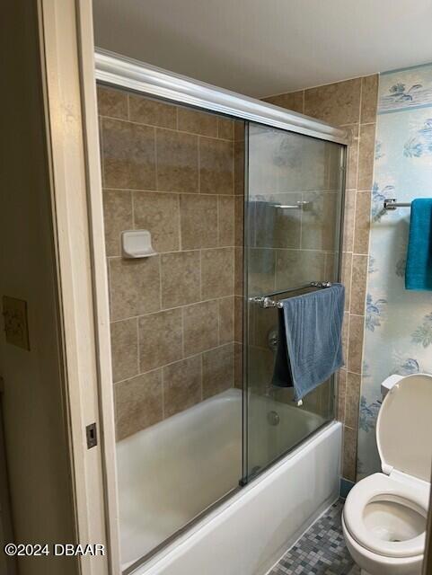 bathroom with shower / bath combination with glass door, tile patterned floors, and toilet