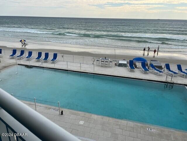 view of pool featuring a beach view and a water view