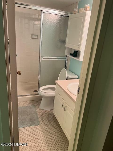 bathroom featuring walk in shower, tile patterned flooring, vanity, and toilet