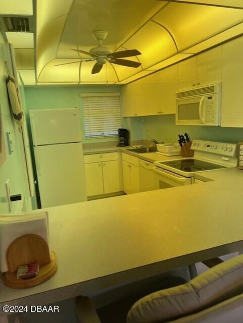 kitchen featuring white appliances, ceiling fan, and sink