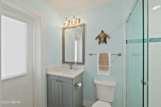 bathroom featuring vanity, toilet, and a shower with door