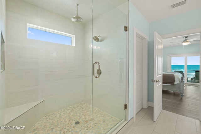 bathroom with a wealth of natural light, a shower with door, and a water view