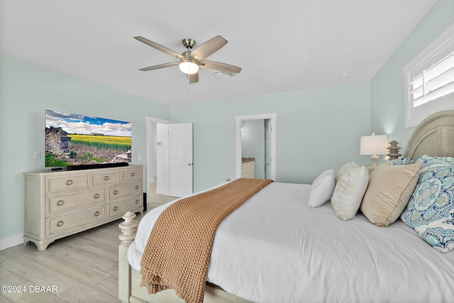 bedroom featuring light hardwood / wood-style flooring, ceiling fan, and connected bathroom