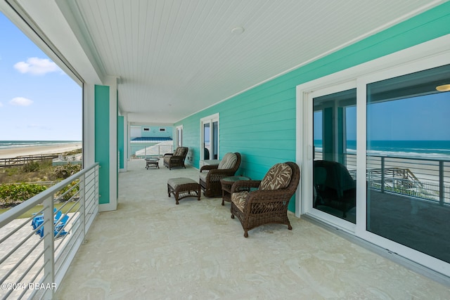 balcony featuring a beach view and a water view