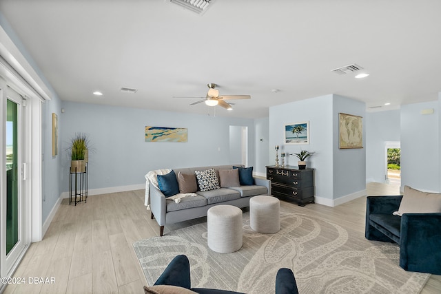 living room with ceiling fan and light hardwood / wood-style flooring