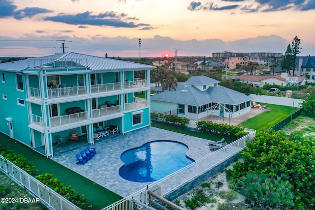 pool at dusk featuring a patio