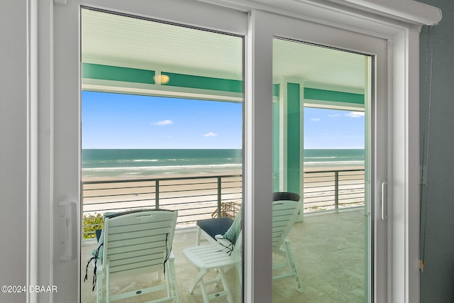 balcony with a water view and a view of the beach