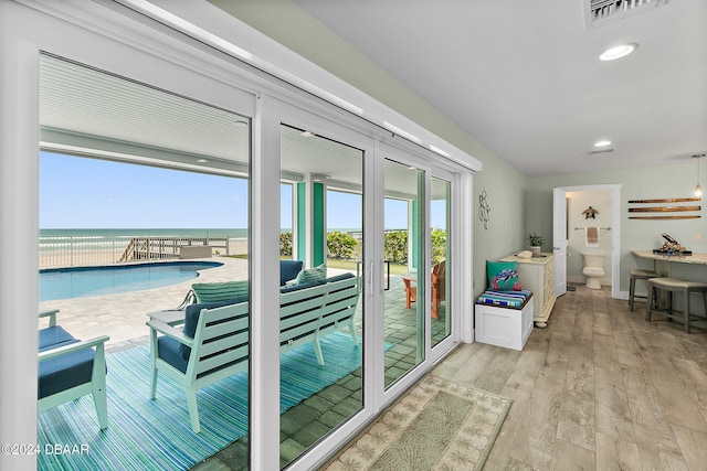 doorway with a water view and light hardwood / wood-style flooring