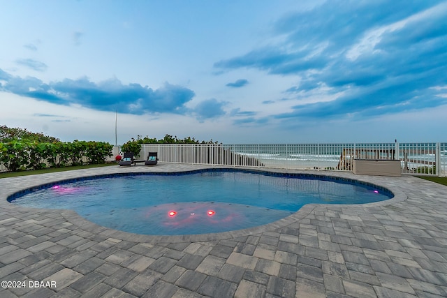 view of swimming pool featuring a patio area and a water view