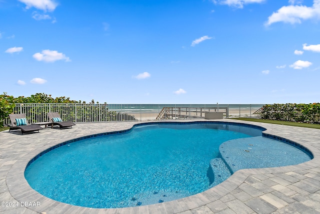 view of swimming pool featuring a water view and a patio area