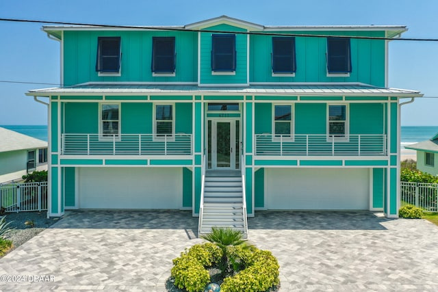 view of front of property with a garage, a water view, and a porch