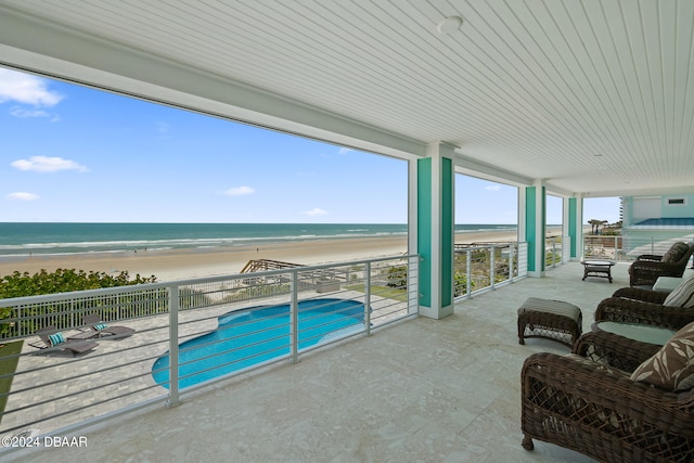 view of swimming pool featuring a view of the beach, a water view, and a patio area