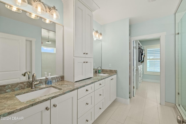 bathroom featuring a tile shower, vanity, and tile patterned floors