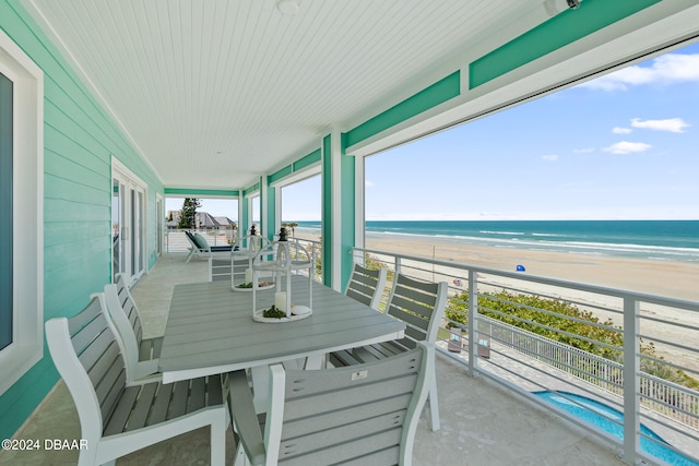 balcony featuring a view of the beach and a water view