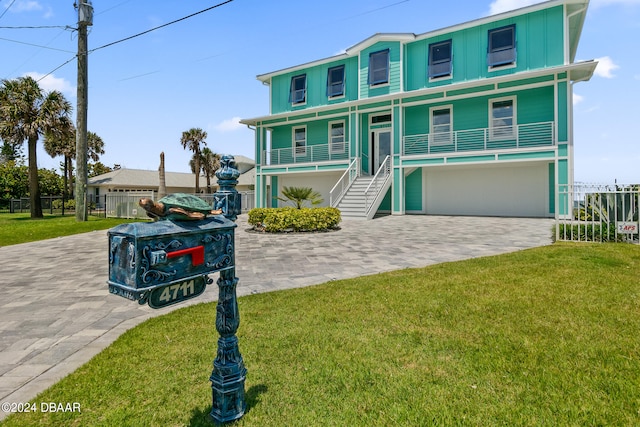 view of front of property featuring covered porch, a garage, and a front yard