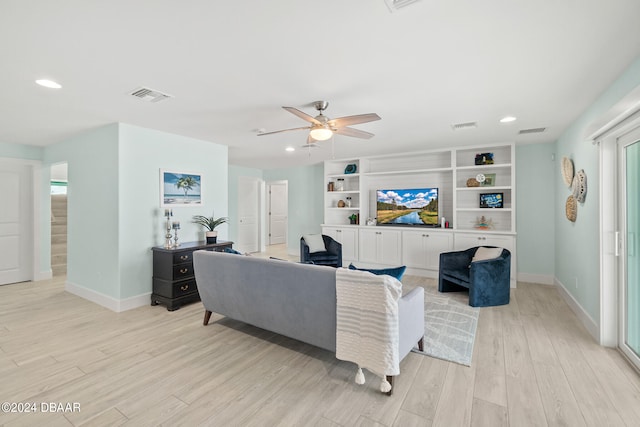 living room with light hardwood / wood-style floors and ceiling fan